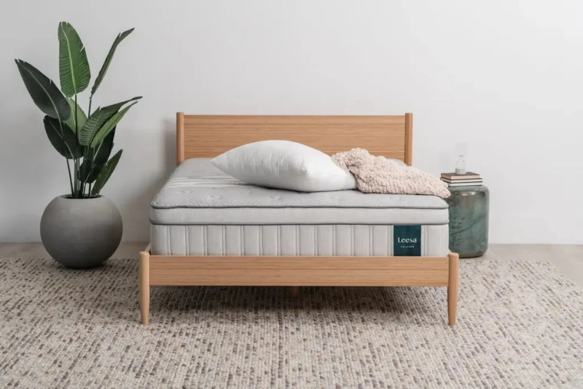 The Leesa Natural Hybrid Mattress with a plant next to it.