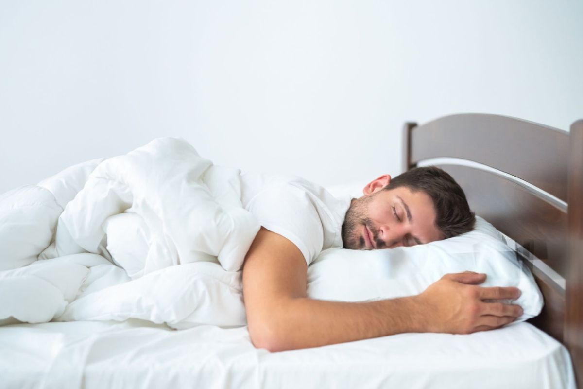 Man sleeping comfortably on a medium mattress that provides a mix of cushioning and spinal support
