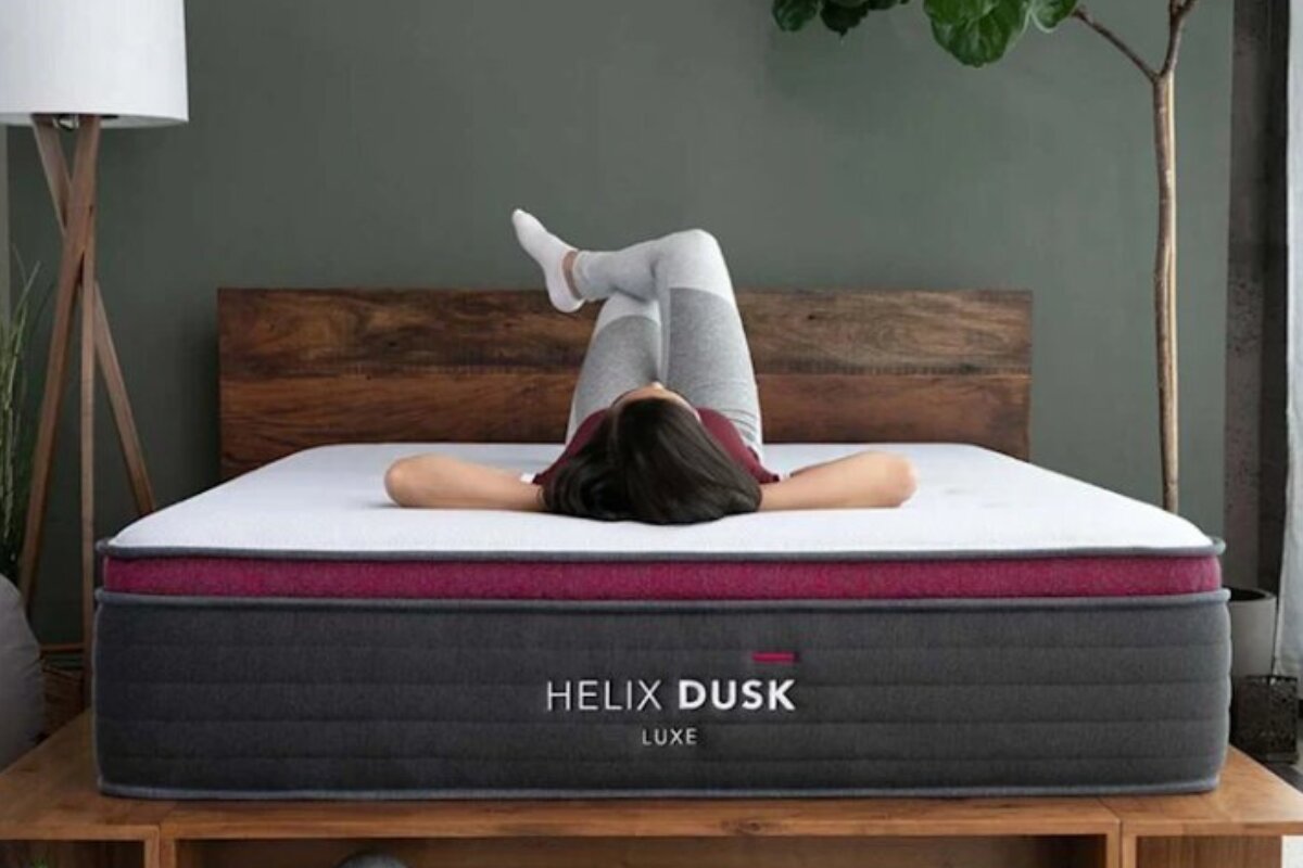 helix dusk luxe mattress with a person relaxing on the bed in a modern bedroom setting