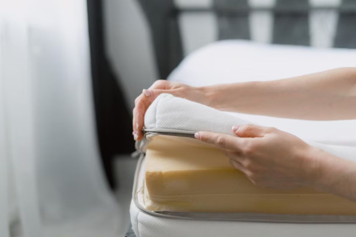 Person opening a mattress cover to inspect foam layers while choosing the right mattress materials and comfort level