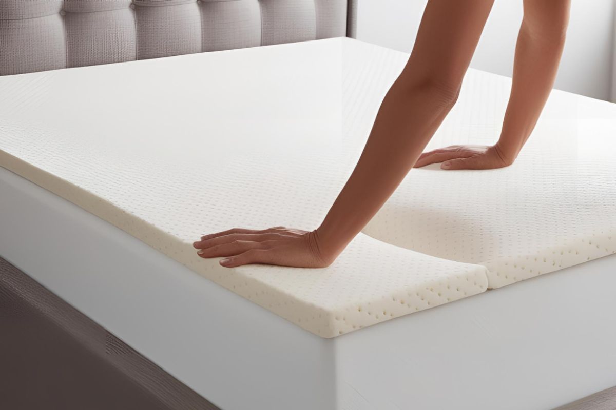 Person placing a foam mattress topper on a bed to make a soft mattress feel firmer and more supportive