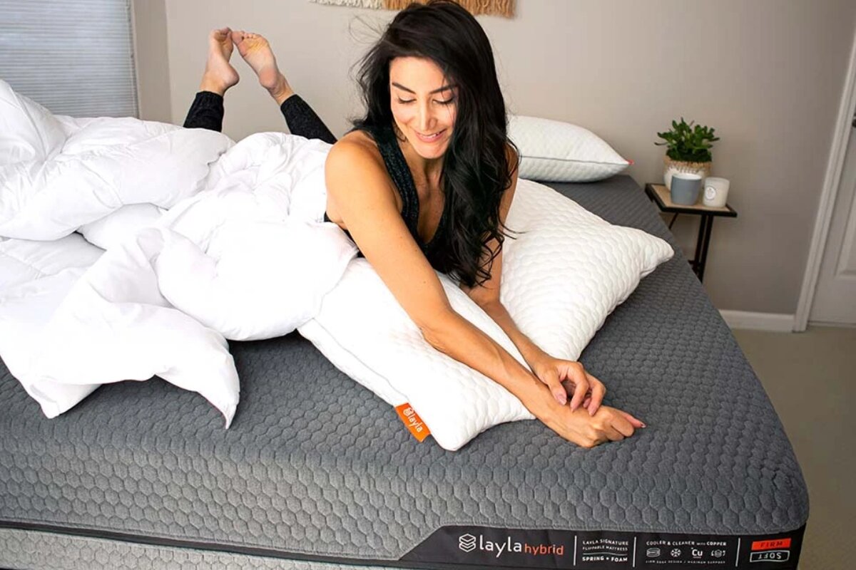 A woman lying down on the Layla Hybrid Mattress.