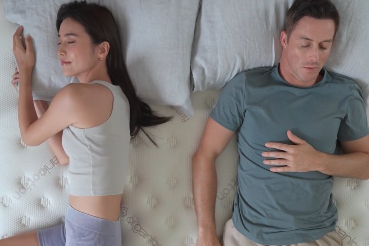 A couple sleeping on a mattress.