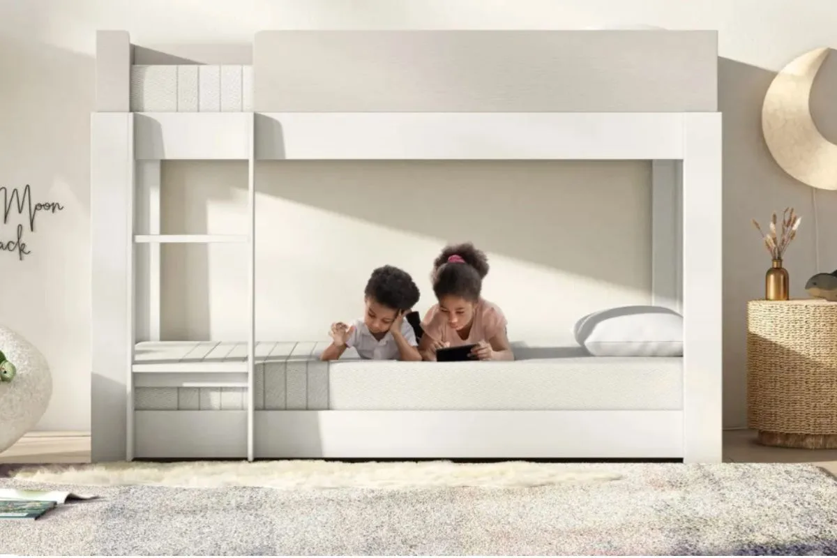 Two kids lying on a bunk bed using a kids mattress