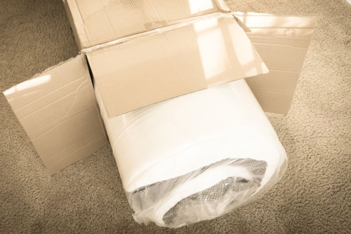 Rolled hybrid mattress still sealed in shipping packaging to explain how long a mattress can safely stay compressed in the box
