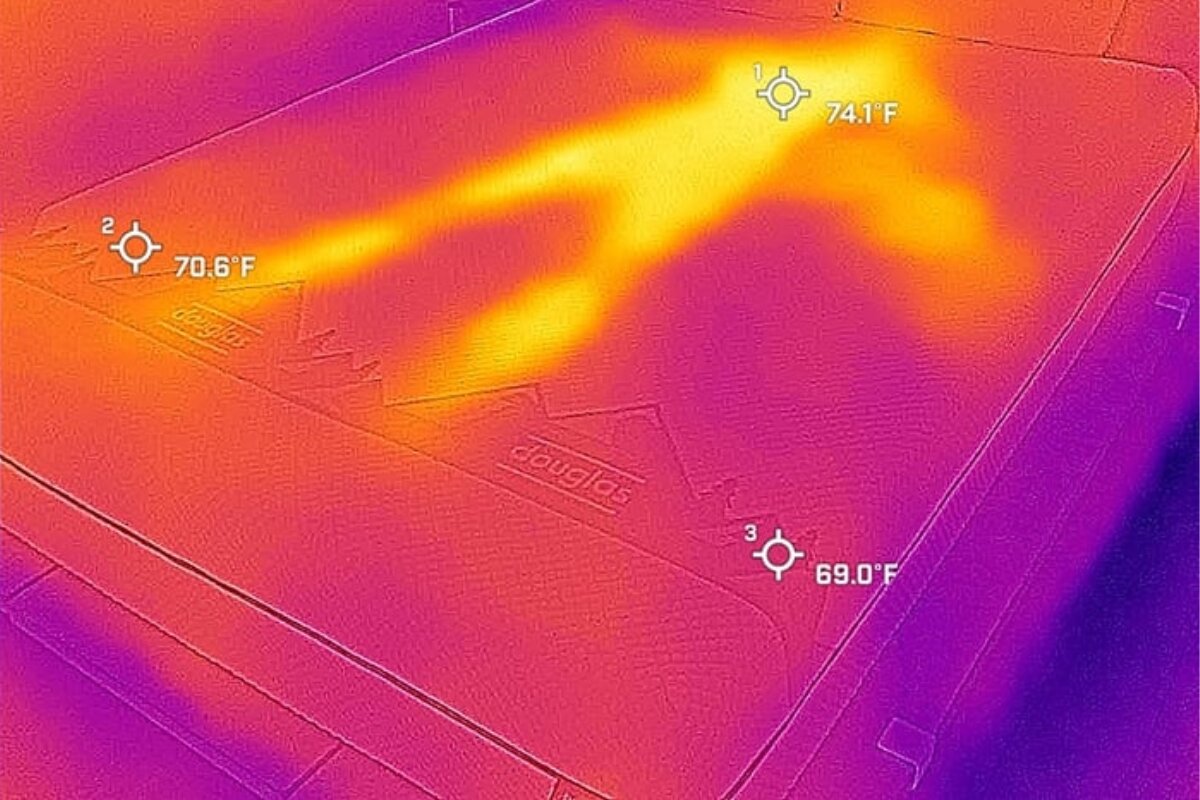 A heat image of a bed after a person has used it, barely visible.