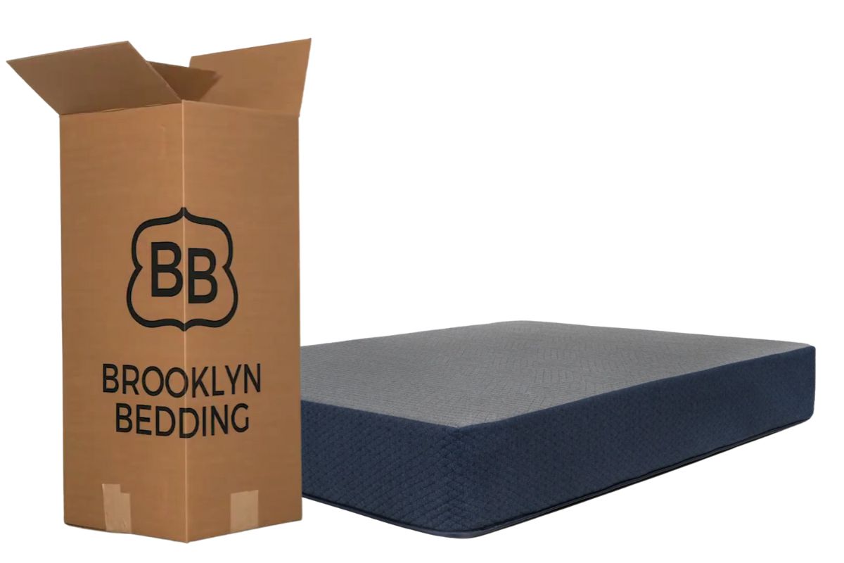 Dreamfoam Essential mattress beside its shipping box, illustrating the boxed mattress setup and return process customers can expect
