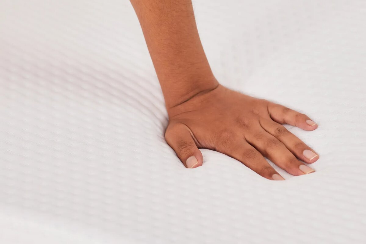hand pressing into emma elite mattress surface showing bounce and responsiveness