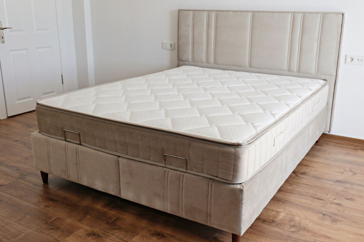 Hybrid mattress on a bed frame in a bedroom, illustrating the typical design and construction of a modern hybrid mattress