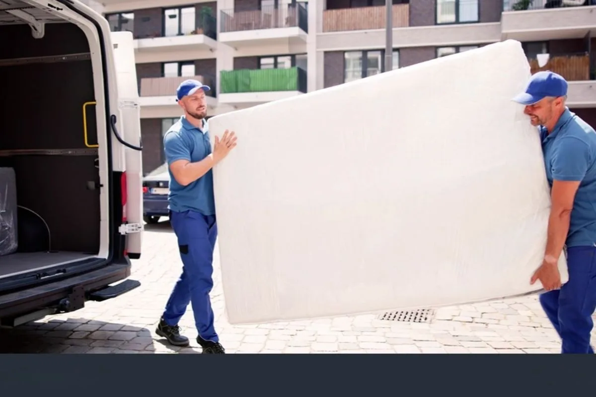 Professional movers carrying a mattress for pickup, showing a convenient mattress removal option when disposing of a memory foam mattress