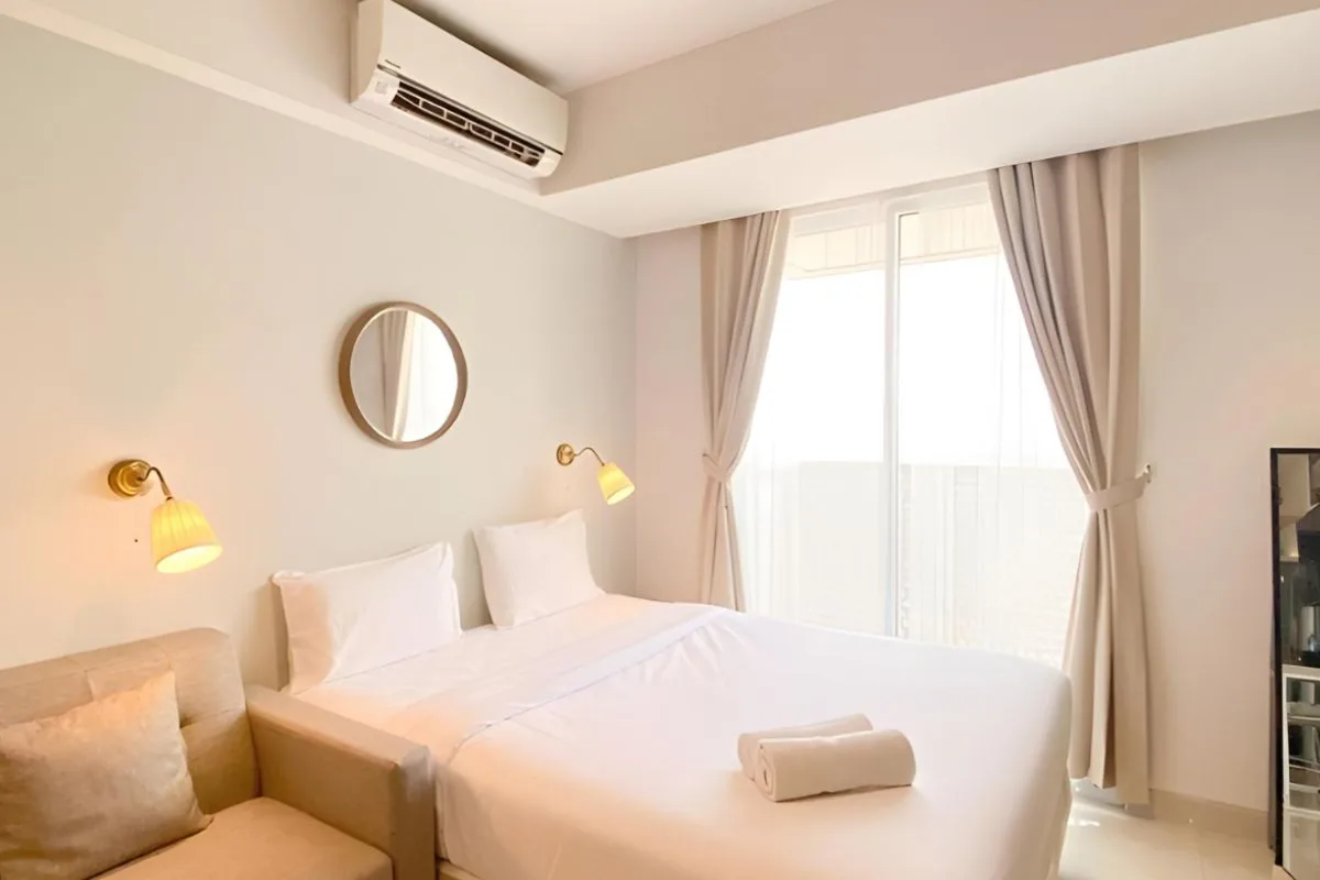 Well-ventilated bedroom with air conditioning and natural light, illustrating how a cooler sleep environment can help reduce heat retention in a memory foam mattress