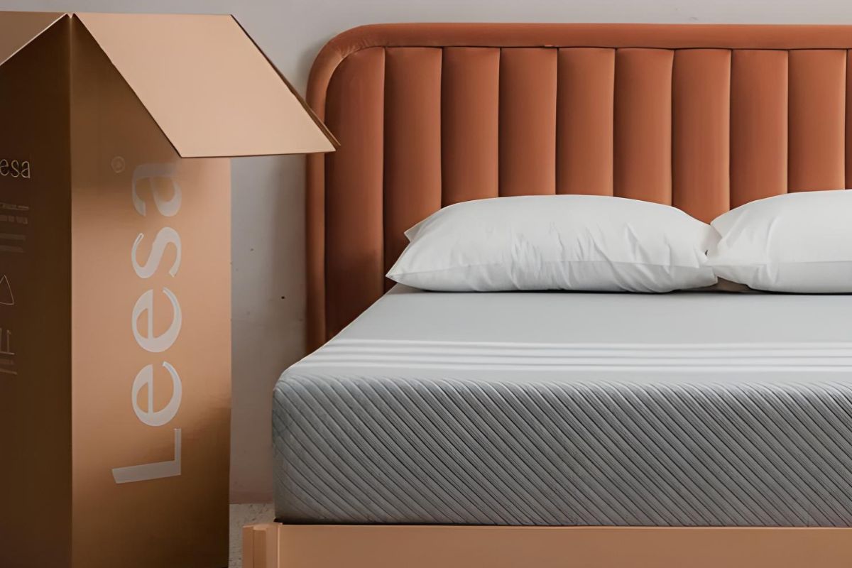Leesa Original Mattress beside its shipping box, illustrating the mattress-in-a-box purchase and return process.