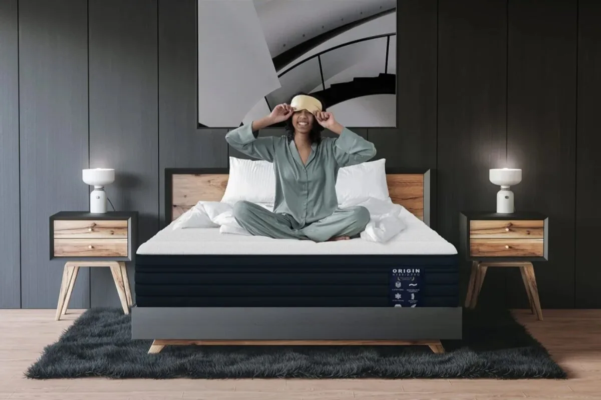 A woman on sitting up on the Origin Hybrid Pro Mattress.