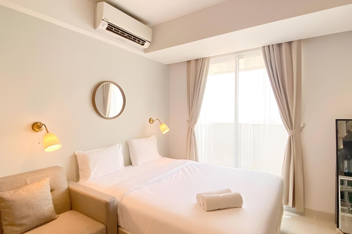 Bright bedroom with a freshly made bed and air conditioning, highlighting ideal room conditions for a memory foam mattress to expand properly within 48 hours