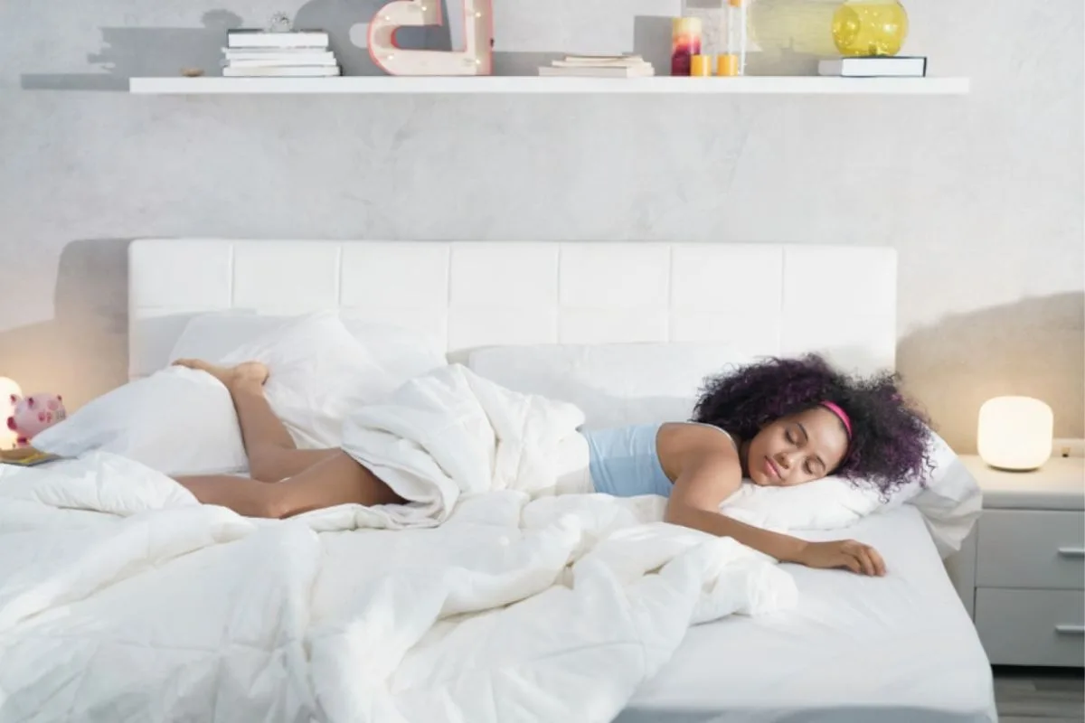 Sleeper resting comfortably on a mattress, representing long-term comfort and support differences between memory foam and hybrid mattresses