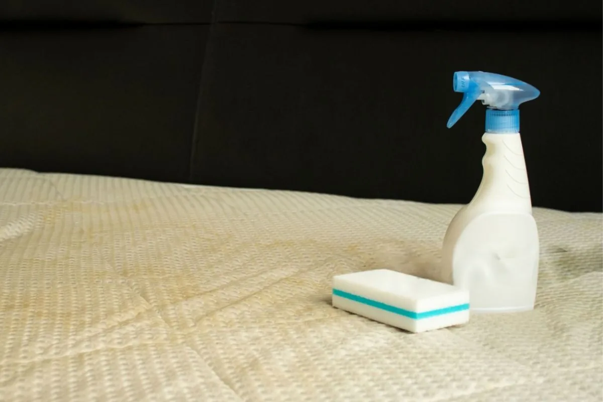 Cleaning supplies placed on a mattress surface, illustrating the tools commonly used to safely clean a memory foam mattress