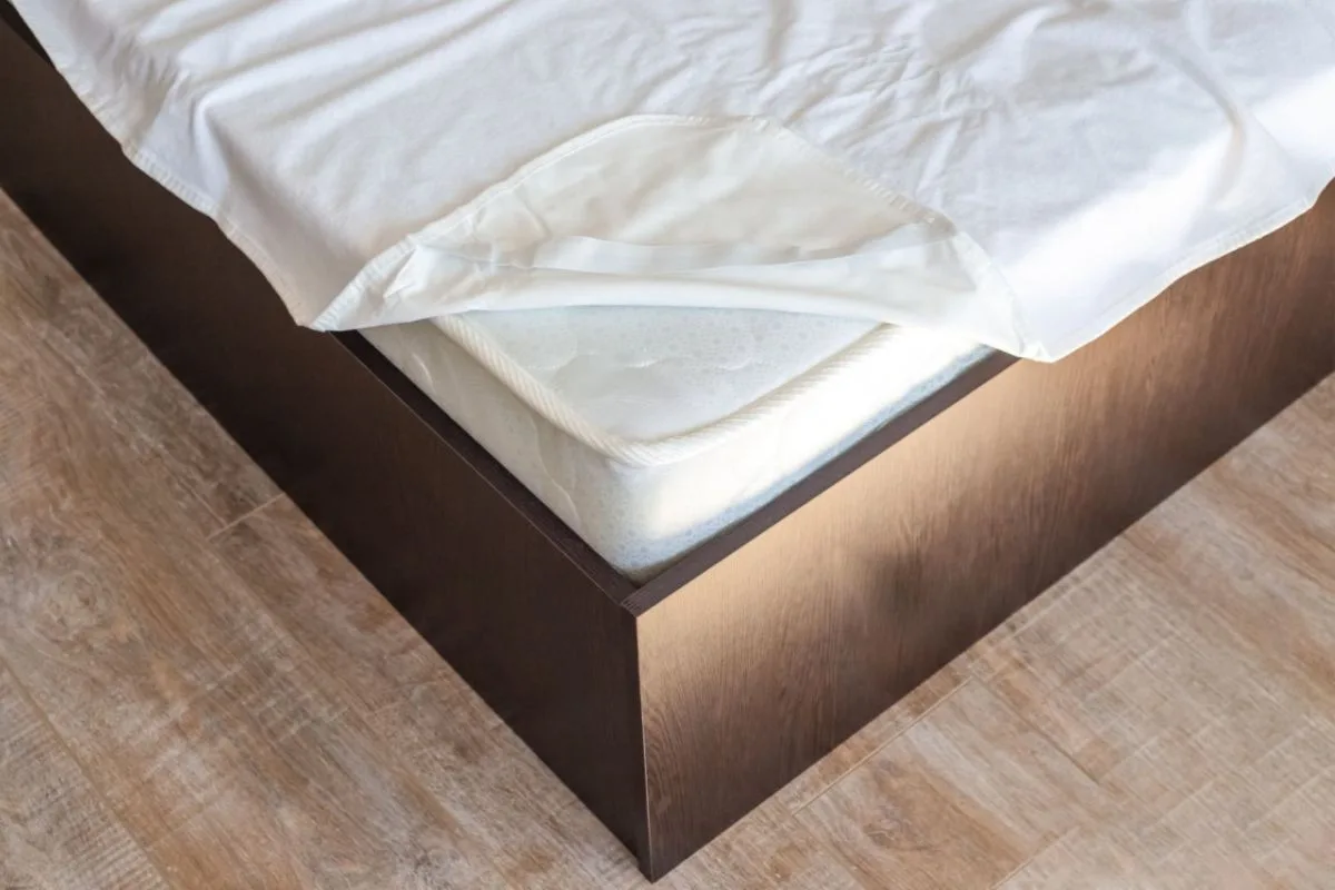 Removing bedding and mattress protector to access the memory foam mattress before deep cleaning and stain removal