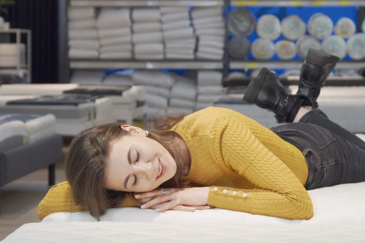 How to Make a Memory Foam Mattress Firmer? Testing mattress firmness in a showroom to compare support levels and determine whether a firmer sleep surface is needed