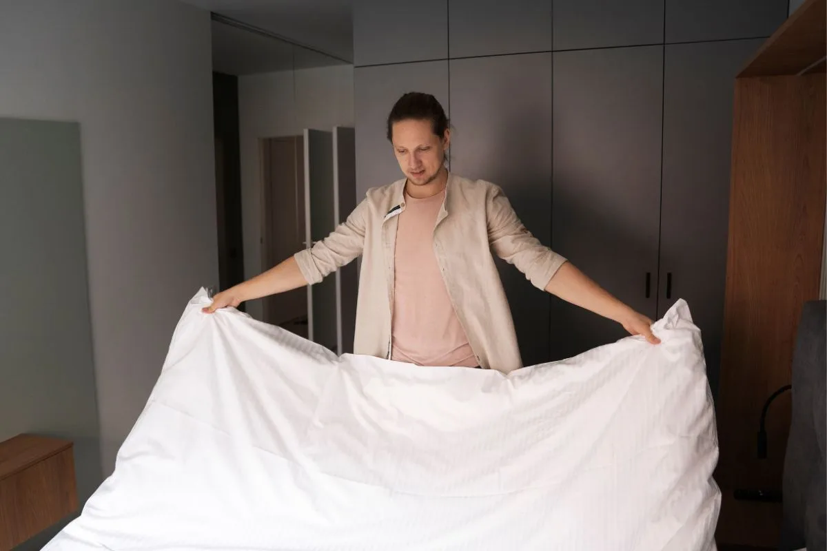 Person folding a mattress bag around a memory foam mattress to protect it from dirt, moisture, and damage during a move
