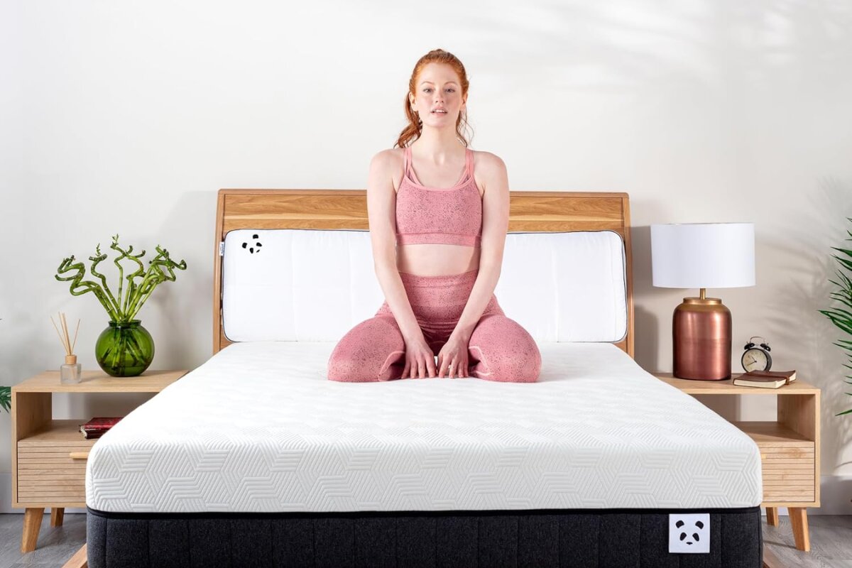 A woman sitting on the Panda Hybrid Bamboo Mattress Pro.