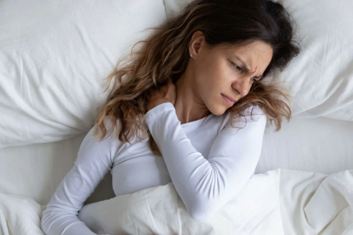 How Long Does a Latex Mattress Last? Sleeper experiencing neck and shoulder discomfort, highlighting how an aging or worn-out mattress may affect comfort and sleep quality over time