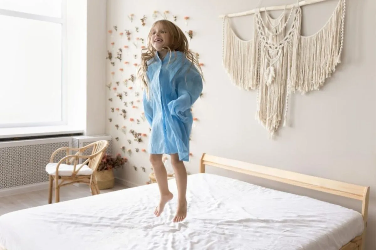 What Is the Difference Between Latex and Memory Foam Mattress? Child jumping on a mattress to demonstrate the responsive bounce and durability commonly associated with latex mattress materials