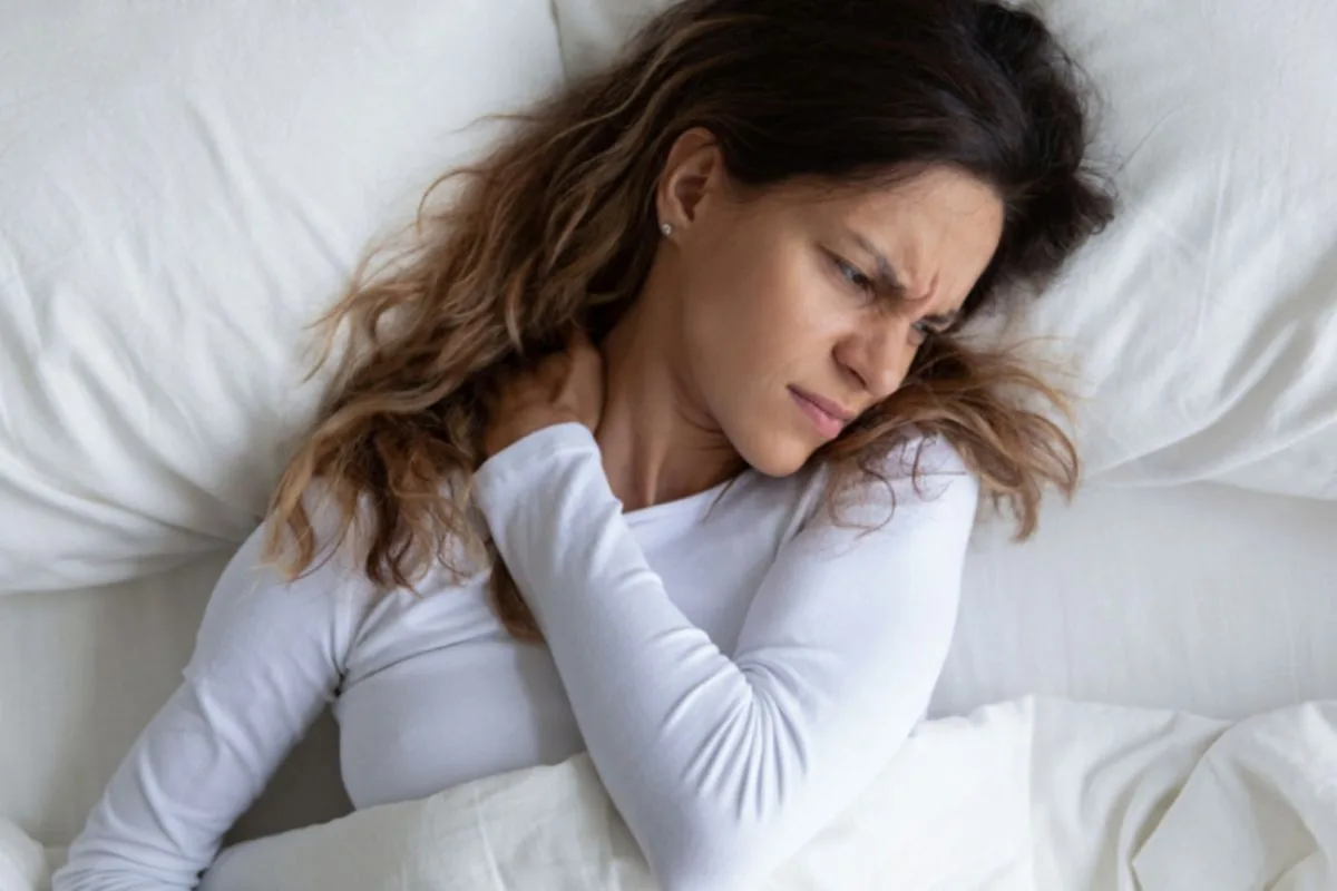 Why Buy a Latex Mattress? Sleeper experiencing neck discomfort, demonstrating how choosing the right latex mattress can help improve spinal alignment and reduce pressure points