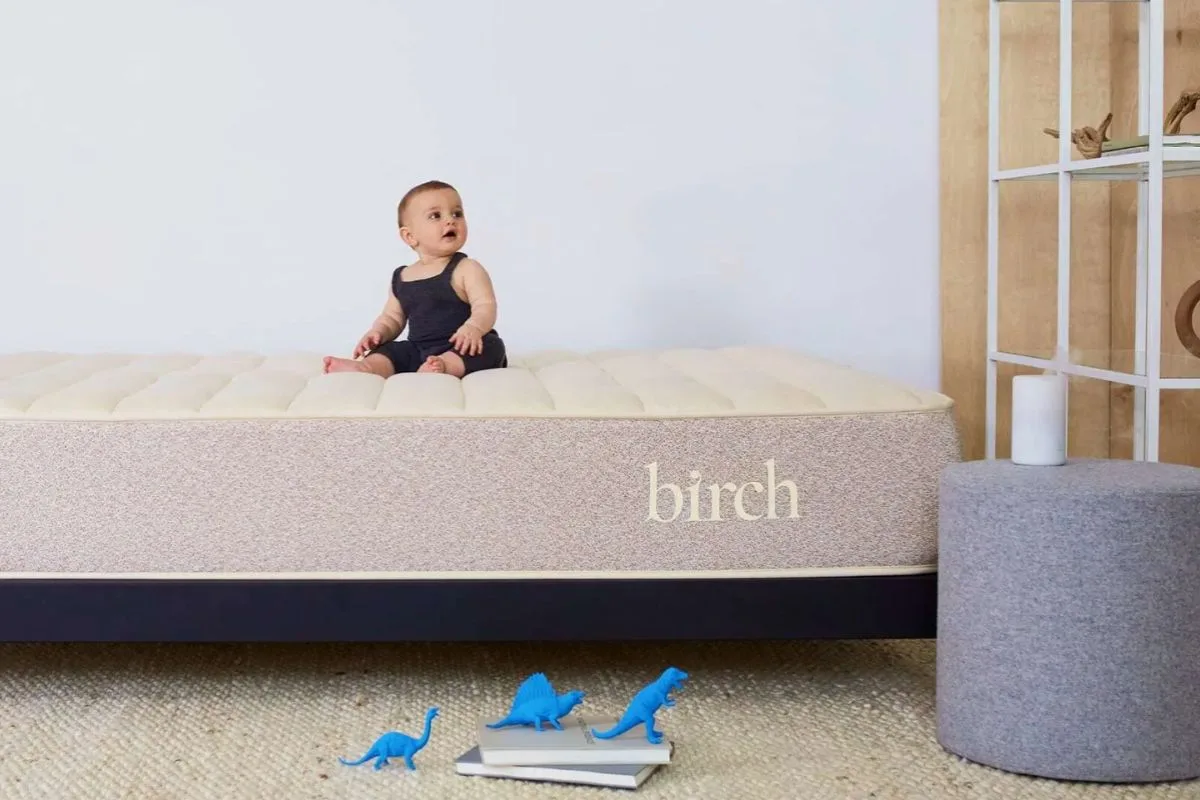 Baby sitting safely on a Birch Natural Mattress, representing everyday use that follows normal warranty-supported conditions