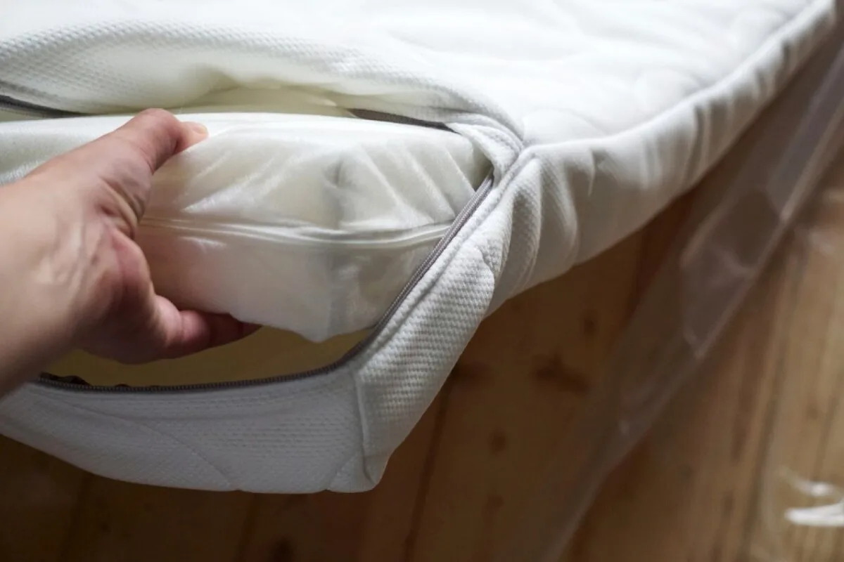 Can You Adjust The Firmness Of A Mattress? A person pulling the foam our of a mattress cover.