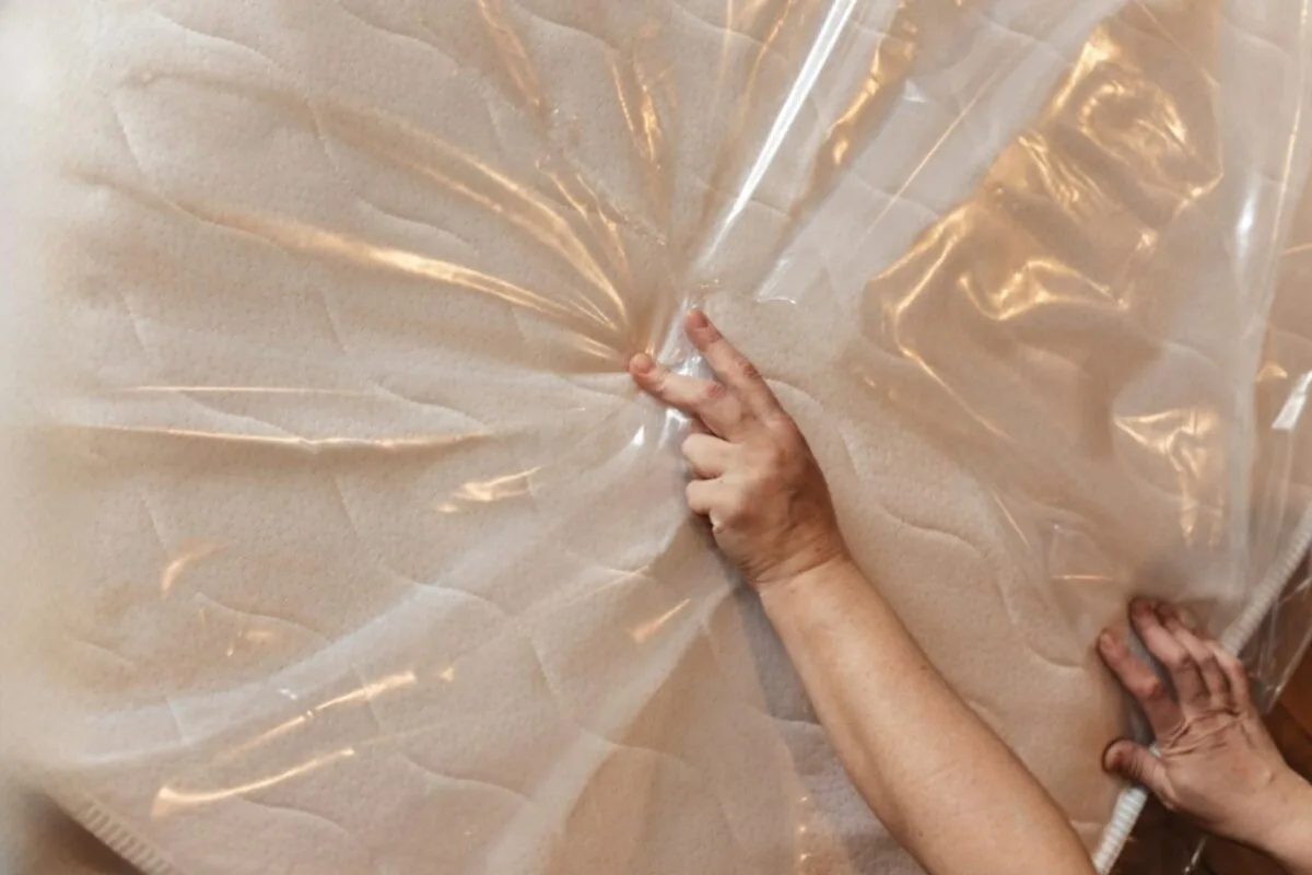 How to Store a Latex Hybrid Mattress Safely? A person holding on to a mattress bag.