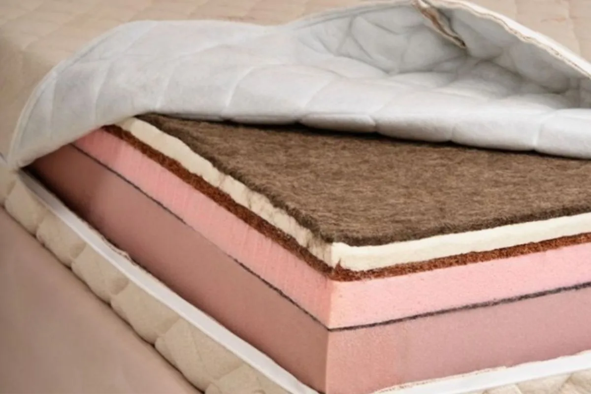 Cutaway view of a latex hybrid mattress showing natural latex, comfort foam, and support core layers inside the mattress