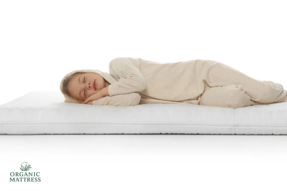 What Is the Best Organic Mattress? A child sleeping on a bed with an organic mattress tag.