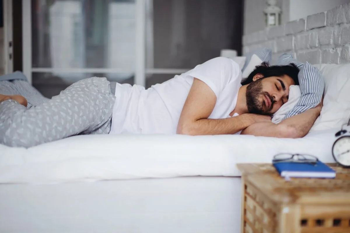 How to Pick a Mattress for Side Sleepers? A man sleeping in a bed.