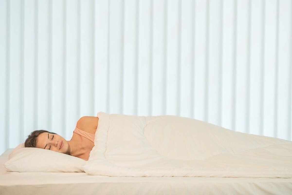 A woman sleeping on a mattress.