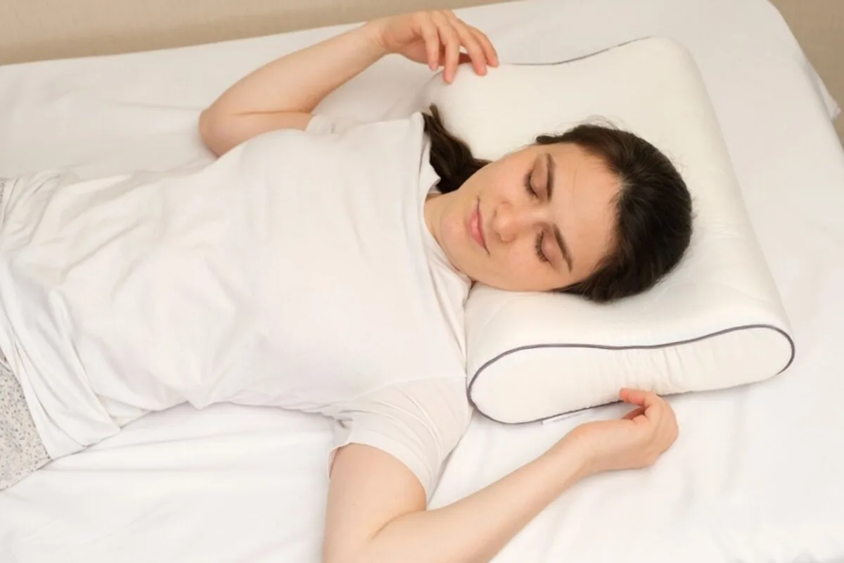 How Should Back Sleepers Sleep? A girl wearing white lying on her back in a bed.