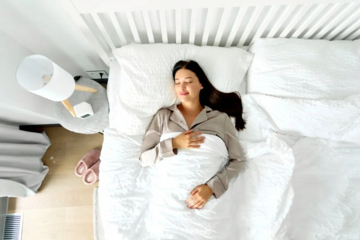 How Should Back Sleepers Sleep? A woman sleeping on a bed in pajamas.