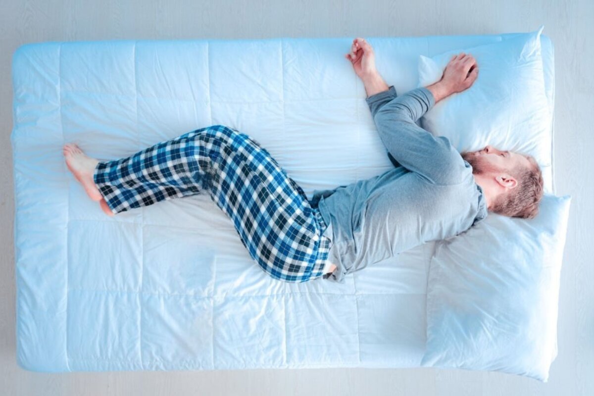 A man sleeping on a blue bed.