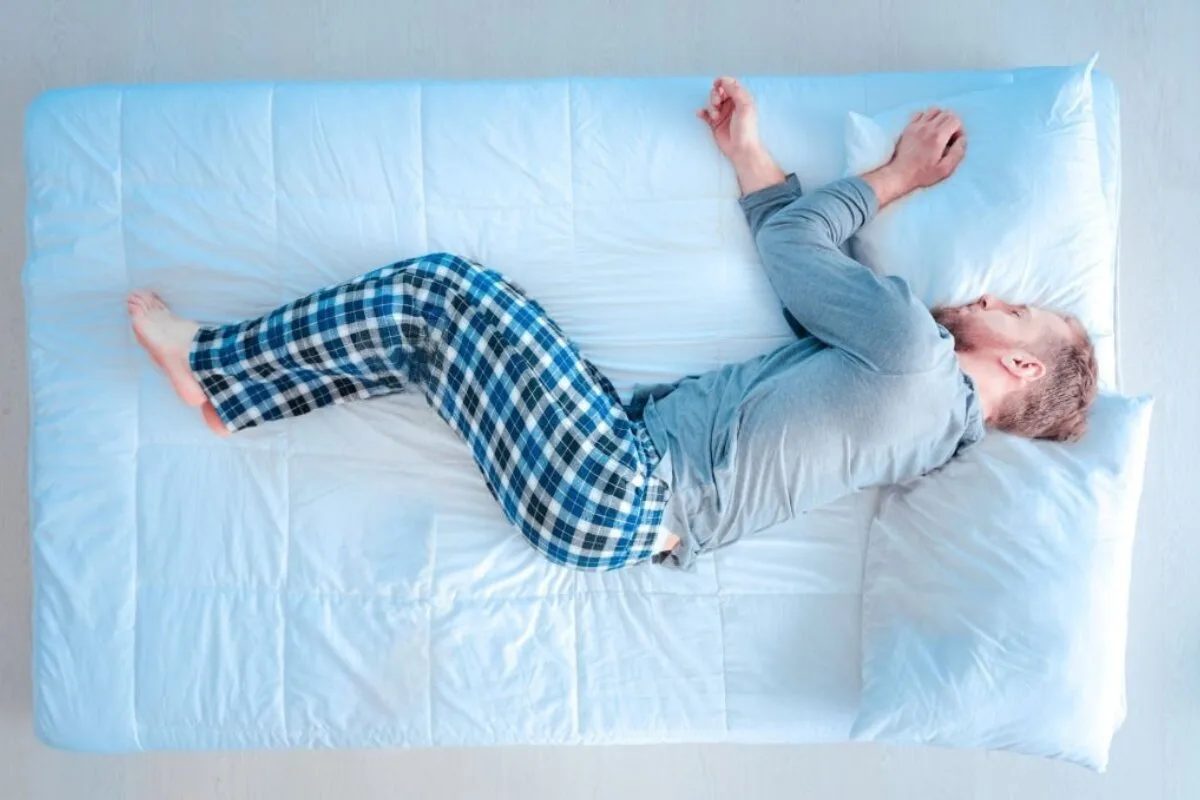 What Firmness Mattress for Side Sleepers? A man sleeping on a blue bed.