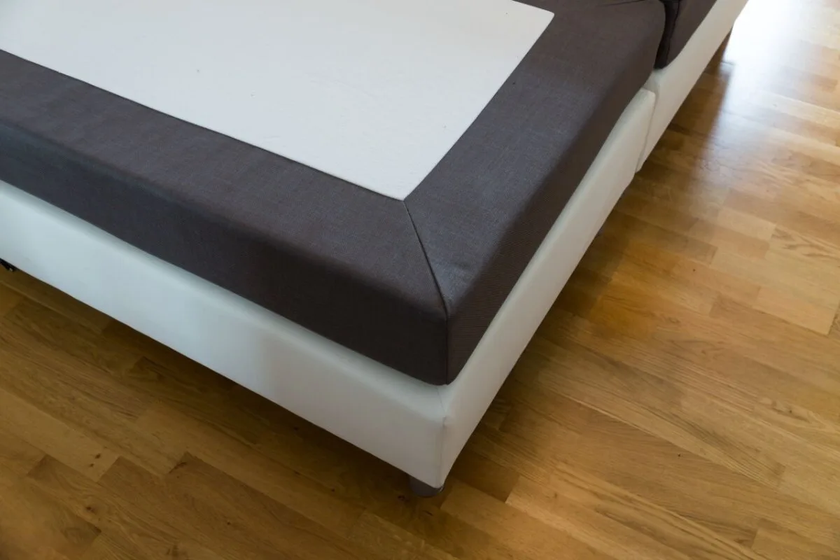 What Type of Mattress Is Best for Combination Sleepers? A closup of a gray bed.