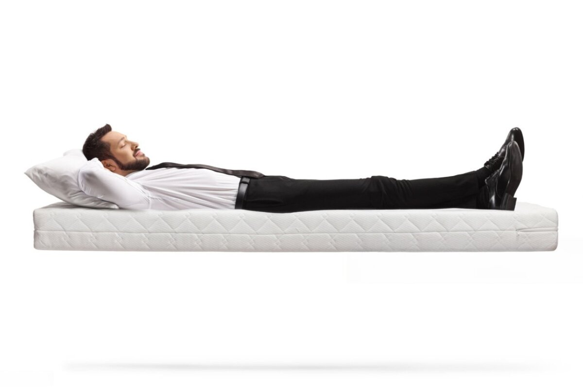 A man lying down on a mattress.