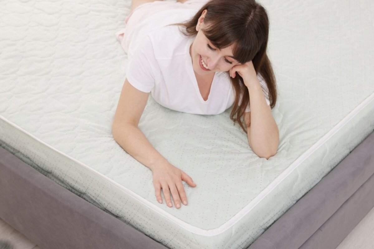 A woman on her stomach on a bed.
