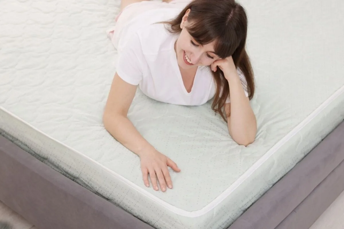 Is a Plush Mattress Good for Stomach Sleepers? A woman on her stomach on a bed.