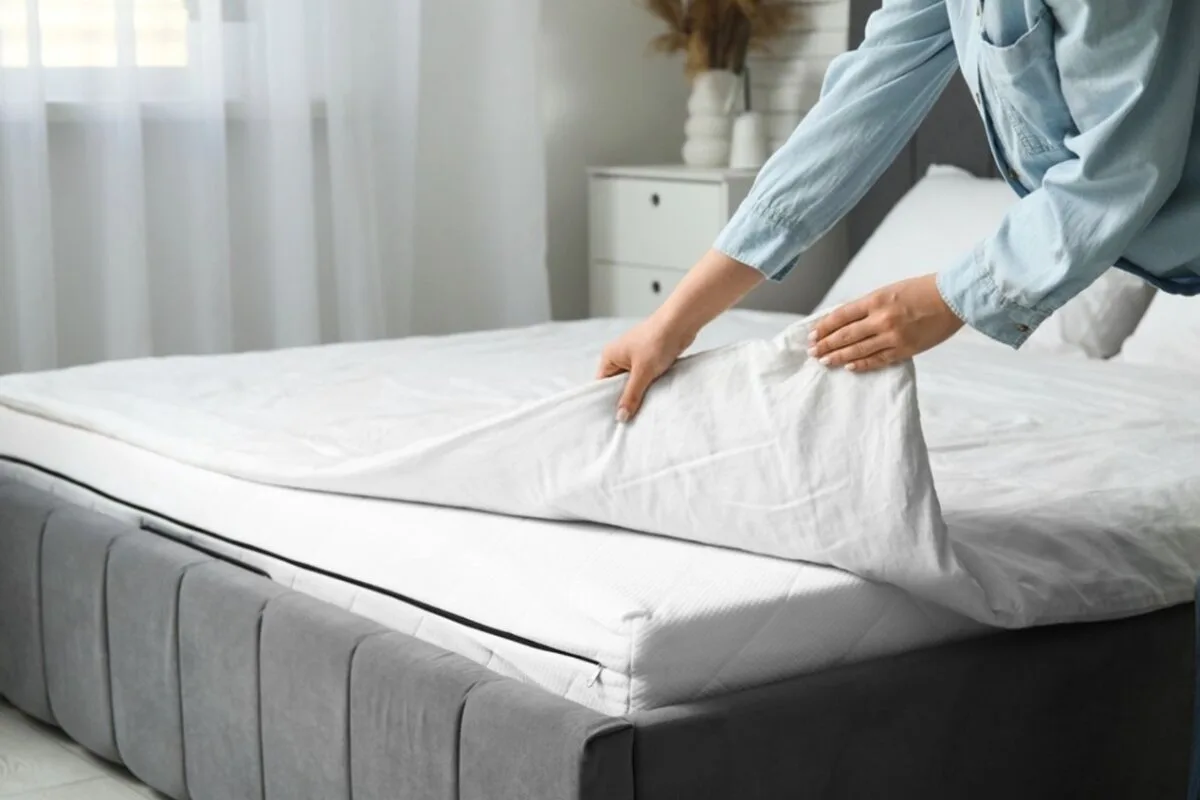 What Does “Combination Sleeper” Mean? A person changing sheets on a bed.