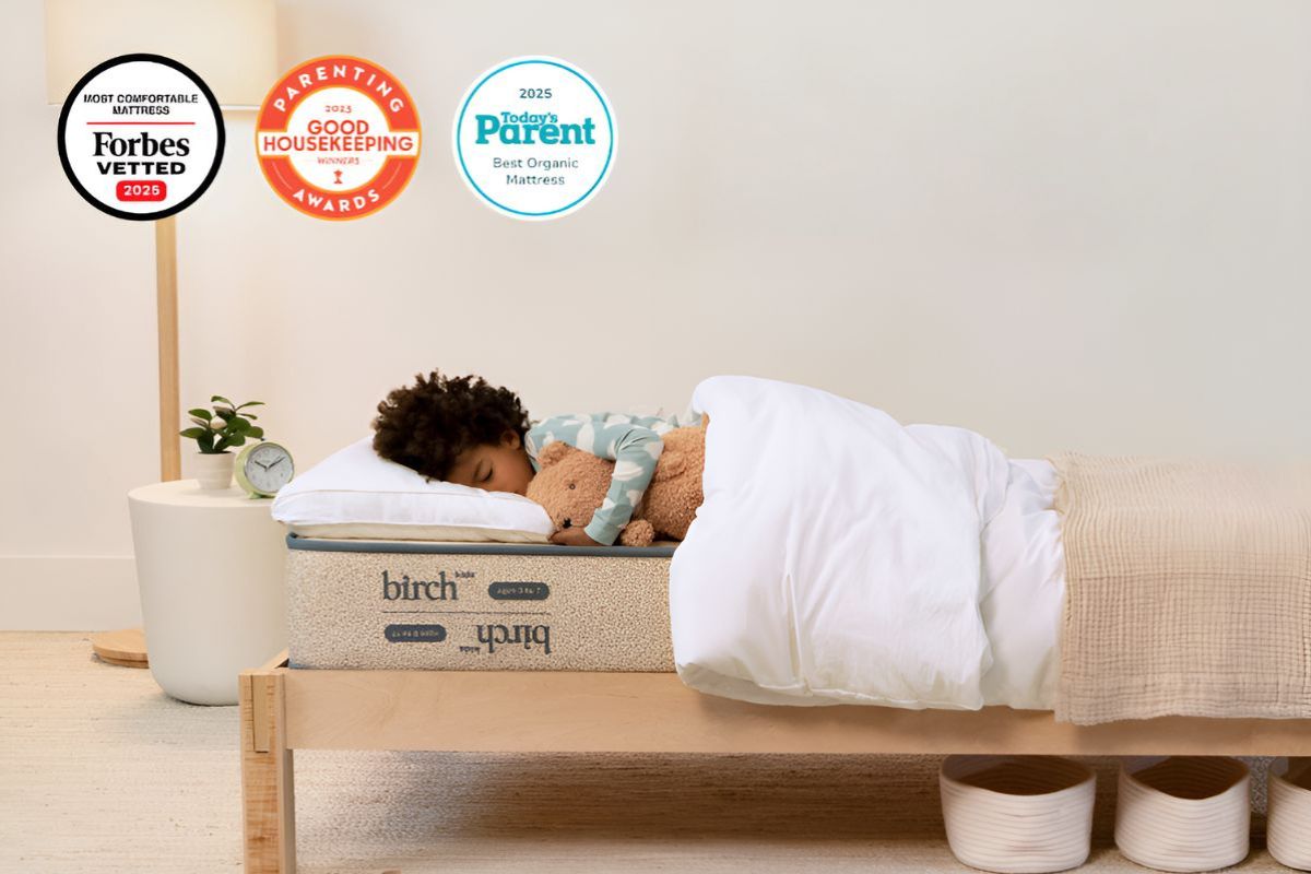 Child sleeping on Birch Kids mattress with safety and award badges