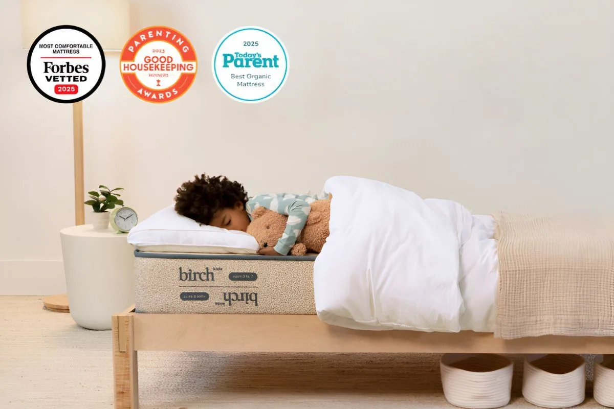 Child sleeping on Birch Kids mattress with safety and award badges
