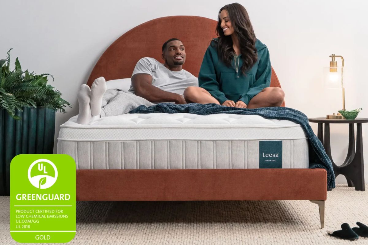 Couple sitting on Leesa Sapira Chill Hybrid mattress showing comfort and support