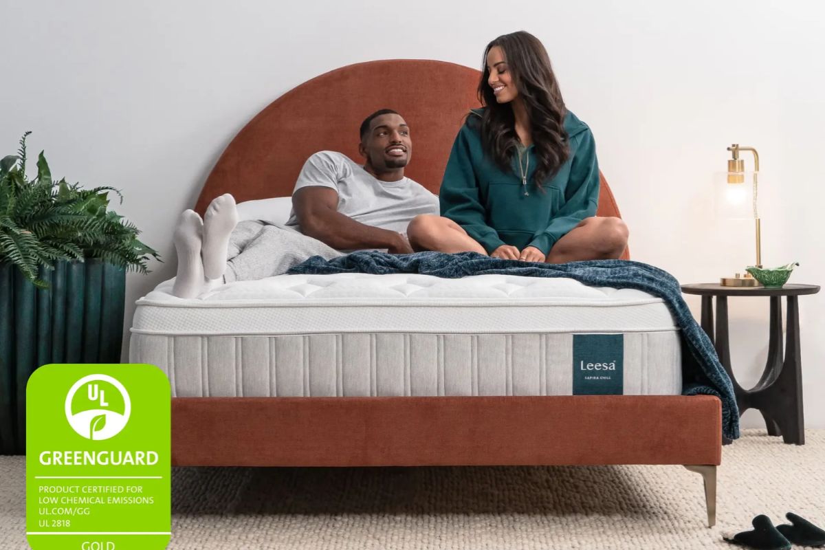 Couple sitting on Leesa Sapira Chill Hybrid mattress showing comfort and support