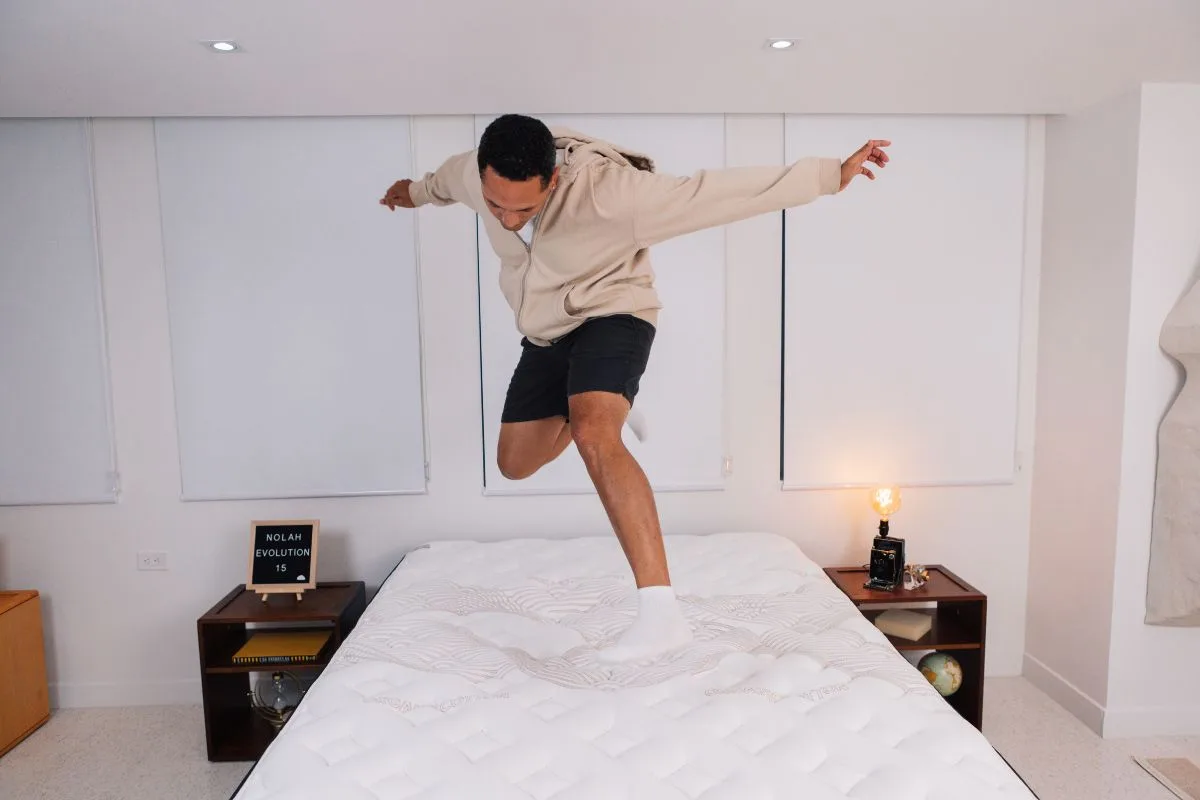A man wearing comfortable clothes jumping on a Nolah Evolution 15