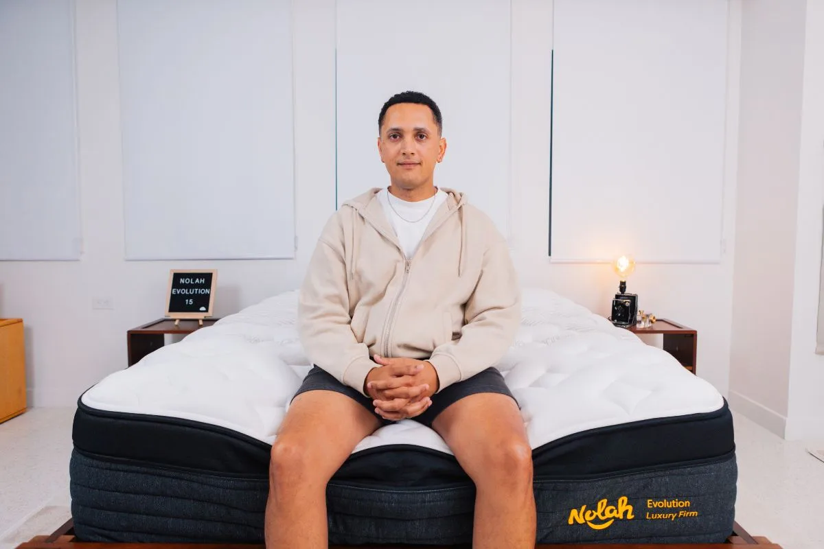 A man wearing comfortable clothes sitting at the edge of the Nolah Evolution 15".