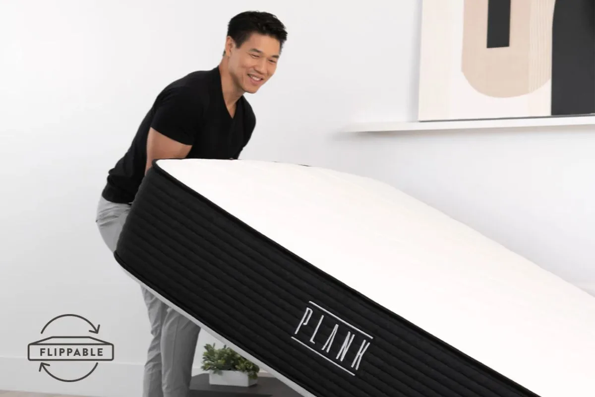 Person lifting mattress showing flippable design and ease of handling